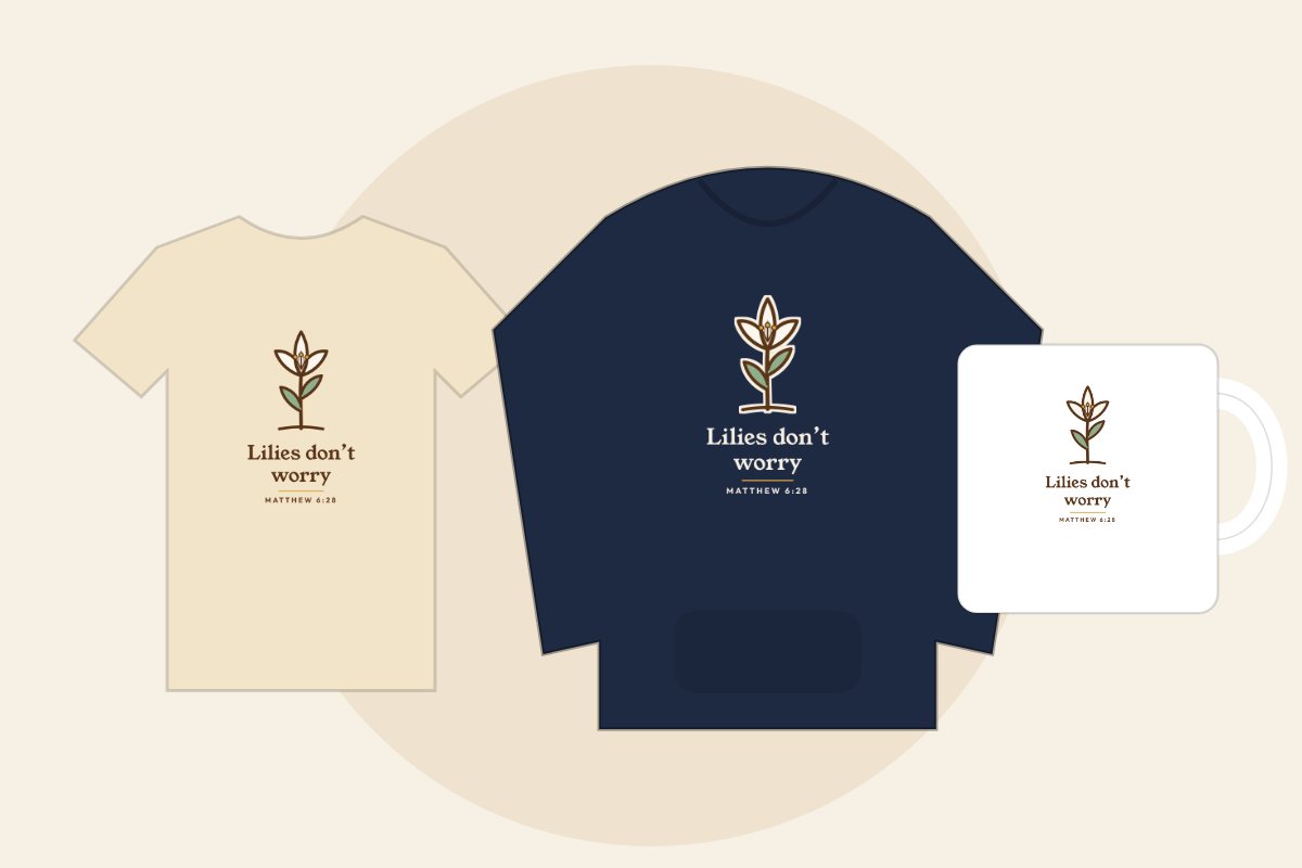 Hand-drawn lily with the words Lilies don’t worry, Matthew 6:28, on a cream tee, navy hoodie and white mug